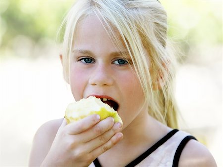 simsearch:400-05014700,k - A funny blond girl eating an apple Fotografie stock - Microstock e Abbonamento, Codice: 400-05014700