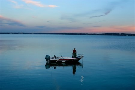 A man fishing in the early morning or early evening from his boat. Stock Photo - Budget Royalty-Free & Subscription, Code: 400-05016655