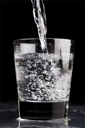 pour of liquor - Pouring a glass of water against a black background Photographie de stock - Aubaine LD & Abonnement, Code: 400-05017171