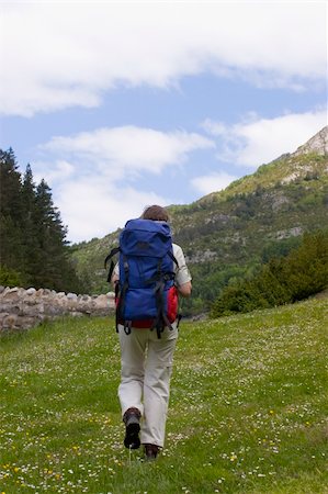 simsearch:400-03965342,k - Woman with backpack hiking on a meadow in the mountains Foto de stock - Royalty-Free Super Valor e Assinatura, Número: 400-05017845