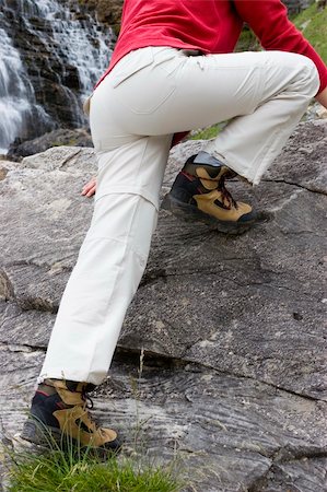 simsearch:400-04997337,k - Woman climbing on a rock with a waterfall in the background Stock Photo - Budget Royalty-Free & Subscription, Code: 400-05018073