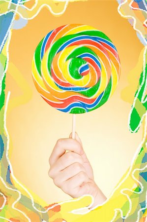 rainbow lollipop in the female hand Stock Photo - Budget Royalty-Free & Subscription, Code: 400-05018805