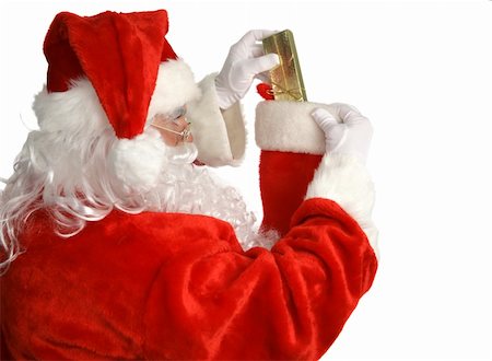 simsearch:400-05008640,k - Santa Claus stuffing a Christmas stocking.  Isolated on white.  (focus is on Santa's face) Photographie de stock - Aubaine LD & Abonnement, Code: 400-05019517