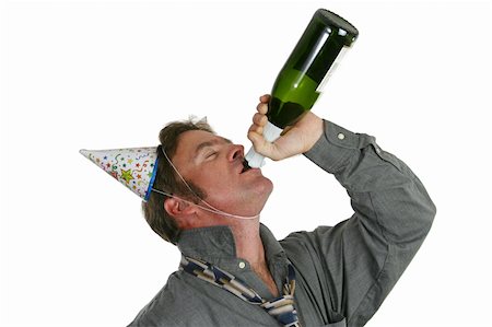 A good-looking man drinking champagne from a bottle and wearing party hats. Stock Photo - Budget Royalty-Free & Subscription, Code: 400-05019523