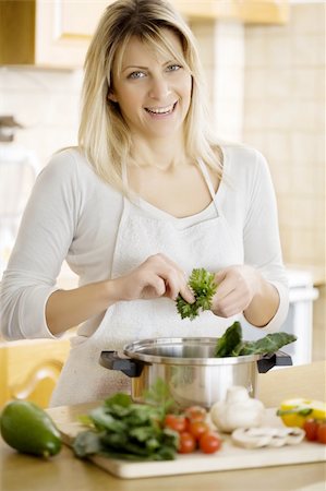 smiling female putting a bunch of healthy ingredients in a cooking pan Stock Photo - Budget Royalty-Free & Subscription, Code: 400-05010235