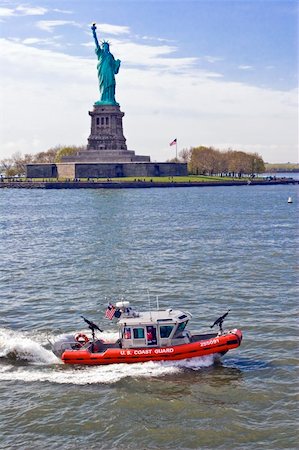 statue of liberty on the flag - U.S. Coast Guard patrols with ready guns around the Statue of Liberty in New York. Stock Photo - Budget Royalty-Free & Subscription, Code: 400-05012214