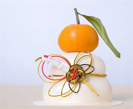 A Japanese New Year rice cake (mochi), with Mandarin and decorative string tied in the shape of a crane. These all symbolise longevity. Stock Photo - Budget Royalty-Free & Subscription, Code: 400-05026467