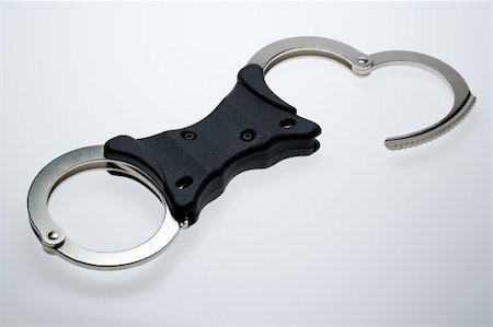 detective suspect - Standard issue rigid bar handcuffs Stock Photo - Budget Royalty-Free & Subscription, Code: 400-05026479