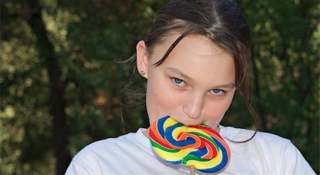a teenage girl has a big swirly lollipop Stock Photo - Budget Royalty-Free & Subscription, Code: 400-05028475