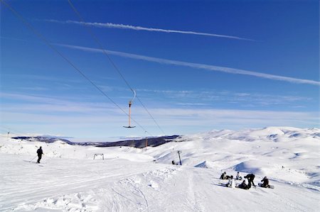 snowboarders near skilift in winter ski resort blue sky Foto de stock - Royalty-Free Super Valor e Assinatura, Número: 400-05028717