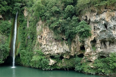 Cascade falling in the emerald waters from a steep shale cliff covered with gold broom and chestnut trees - Cascade des Baumes, Saint-Rome-de-Tarn, Aveyron, France Stock Photo - Budget Royalty-Free & Subscription, Code: 400-05029864