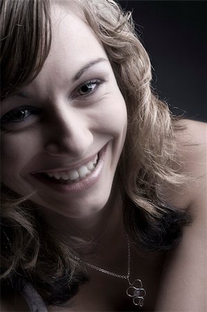 Studio portrait of a teenage model smiling her teeths bare. Foto de stock - Super Valor sin royalties y Suscripción, Código: 400-05020205