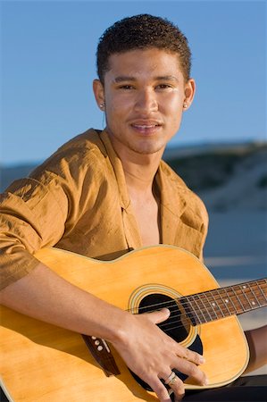 Young musician holding his guitar and looking at the camera Stock Photo - Budget Royalty-Free & Subscription, Code: 400-05020868