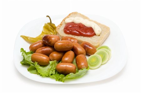Sausages with garnish on white plate. Junk food image series Stock Photo - Budget Royalty-Free & Subscription, Code: 400-05020950