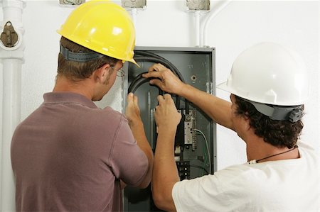 Electricians working together to install a breaker panel.  Models are actual electricians - all work is performed according to industry standard code and safety practices. Photographie de stock - Aubaine LD & Abonnement, Code: 400-05021213