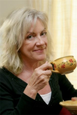 A beautiful mature woman enjoying a cup of coffee.  Soft focus applied. Stock Photo - Budget Royalty-Free & Subscription, Code: 400-05021796