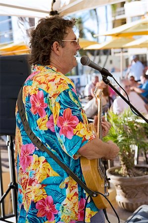 person in hawaiian shirt - A musician in a Hawaiian shirt entertaining a crowd at a beachside cafe. Stock Photo - Budget Royalty-Free & Subscription, Code: 400-05021956