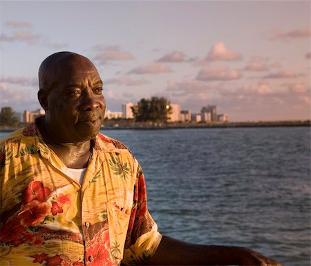 A caribbean man enjoying a tropical sunset over the water. Stock Photo - Budget Royalty-Free & Subscription, Code: 400-05021964