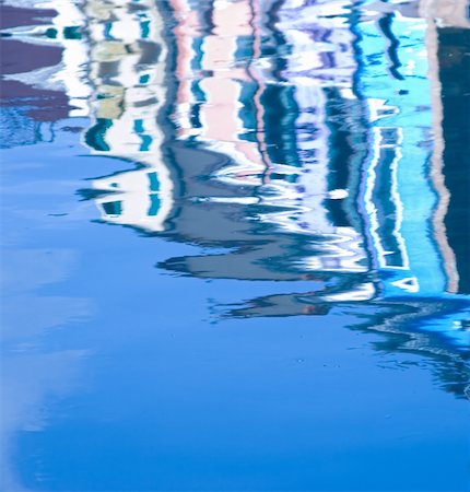 Colors from the row of colorful houses are reflected in the water ? Italy. Venice. Burano. Foto de stock - Royalty-Free Super Valor e Assinatura, Número: 400-05022043