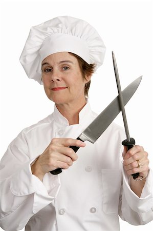 A competent female chef sharpening her knives.  Isolated on white. Stock Photo - Budget Royalty-Free & Subscription, Code: 400-05022158