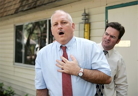 A mature businessman suffering from sudden chest pain.  A coworker looks worried. Photographie de stock - Aubaine LD & Abonnement, Code: 400-05022210