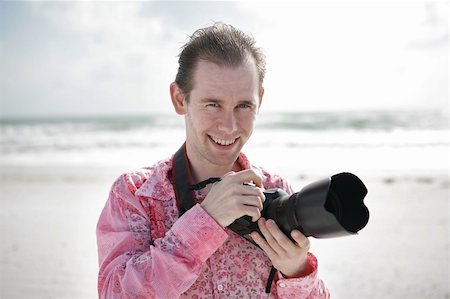 Portrait of a handsome young photographer on the beach. Photographie de stock - Aubaine LD & Abonnement, Code: 400-05022225