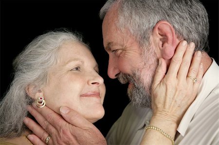 simsearch:400-04109826,k - Closeup of a romantic, loving middle aged couple.  Black background Fotografie stock - Microstock e Abbonamento, Codice: 400-05022235