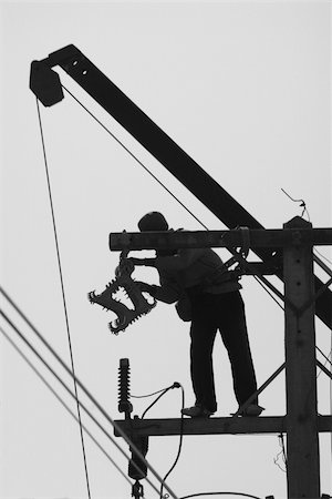 electricity pole silhouette - Silhouette of man performing maintenance work on a pole for electric wiring. Black and white photo. Foto de stock - Super Valor sin royalties y Suscripción, Código: 400-05023603