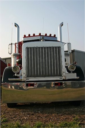This is a picture of the front of a large semi truck, taken at a low stance with a slight angle to give the feeling of movement and power. Photographie de stock - Aubaine LD & Abonnement, Code: 400-05035258