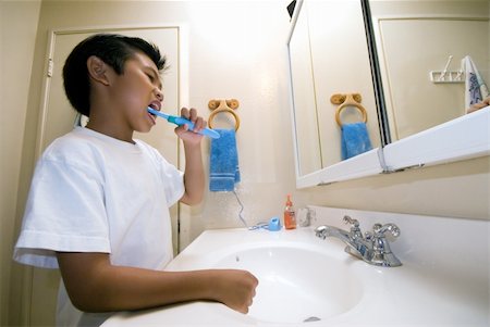 Little asian boy at home in bathroom looking in mirror while brushing his teeth Stock Photo - Budget Royalty-Free & Subscription, Code: 400-05035705