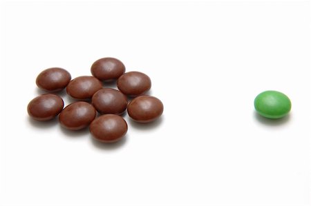 Colored Chocolate Beans 4 - One green bean outcast by the rest Fotografie stock - Microstock e Abbonamento, Codice: 400-05036046