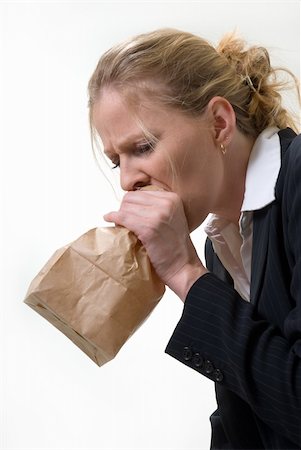 Blond woman holding a brown paper bag over mouth with a distraught expression as if having a panic attack or being nauseated Foto de stock - Super Valor sin royalties y Suscripción, Código: 400-05037649