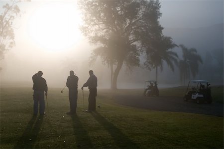 Early morning golfers silhouetted in a dense fog with a rising sun Photographie de stock - Aubaine LD & Abonnement, Code: 400-05038623