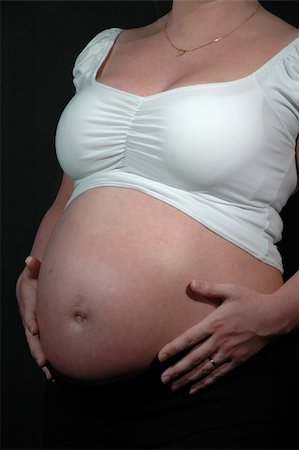 simsearch:400-06567245,k - Pregnant woman holding here hands on her unborn baby. Stockbilder - Microstock & Abonnement, Bildnummer: 400-05039693