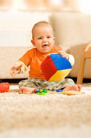 Baby boy sitting on the ground and playing with a colorful cube Stock Photo - Budget Royalty-Free & Subscription, Code: 400-05039996