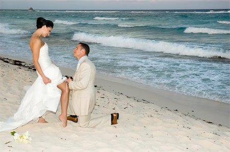 Groom removing the brides garter belt on the beach. Stock Photo - Budget Royalty-Free & Subscription, Code: 400-05030005