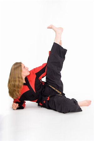 Female martial artist in red and black uniform stretching. Stock Photo - Budget Royalty-Free & Subscription, Code: 400-05031200