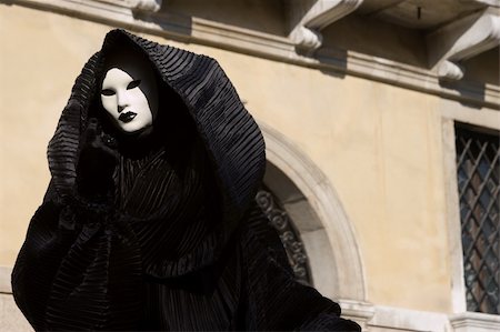 Figure in the black costume with hood, and white mask. Venice. Masquerade. Foto de stock - Royalty-Free Super Valor e Assinatura, Número: 400-05031264