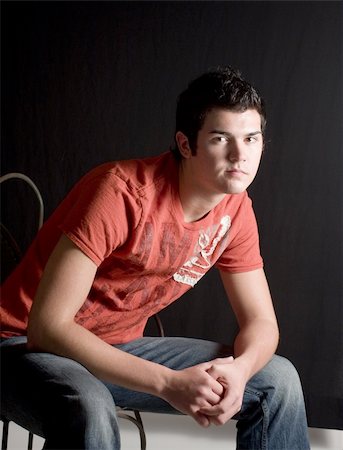 simsearch:400-03995127,k - Late teen Male model in red t-shirt and jeans sitting in casual poses Stock Photo - Budget Royalty-Free & Subscription, Code: 400-05031543
