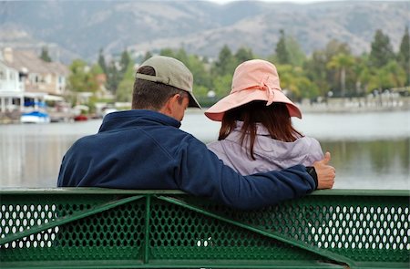 A couple sit on a bench by a lake, the man makes the thumbs up gesture. Photographie de stock - Aubaine LD & Abonnement, Code: 400-05031641