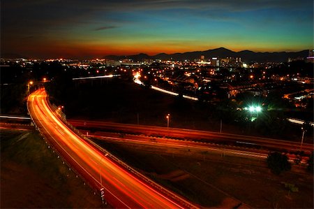 Sunset behind mountain with city light and highway as foreground. Stock Photo - Budget Royalty-Free & Subscription, Code: 400-05031943