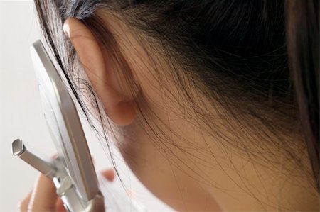 fingers in ears - Young woman listening to a cell phone Stock Photo - Budget Royalty-Free & Subscription, Code: 400-05032019