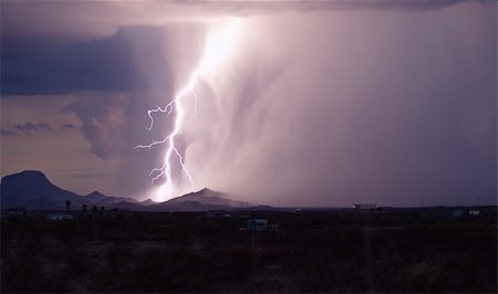 rain storm clouds lightening - Strong lightning bolt striking the ground during a storm lightning up hills Stock Photo - Budget Royalty-Free & Subscription, Code: 400-05045022