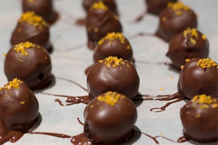 Close up of 3 rows of orange flavored chocolate truffles sprinkled w/ orange rind. Foto de stock - Super Valor sin royalties y Suscripción, Código: 400-05049741