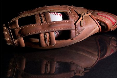 A baseball in a glove sitting on a black reflective surface. Stock Photo - Budget Royalty-Free & Subscription, Code: 400-05041047