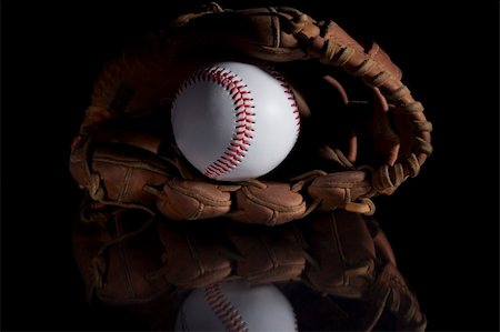 A baseball in a glove sitting on a black reflective surface. Stock Photo - Budget Royalty-Free & Subscription, Code: 400-05041048