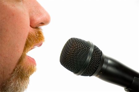 Bearded man speaking into a microphone with only nose, cheeks and mouth visible. Isolated on white background. Stock Photo - Budget Royalty-Free & Subscription, Code: 400-05041068