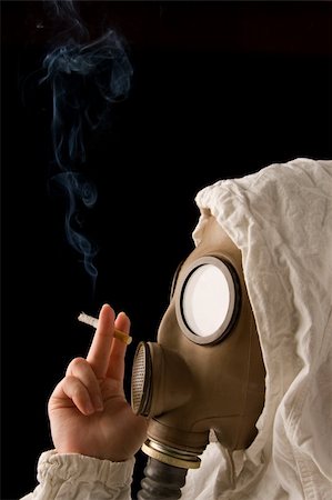 Person in gas mask smoking cigarette on dark background Stock Photo - Budget Royalty-Free & Subscription, Code: 400-05041598