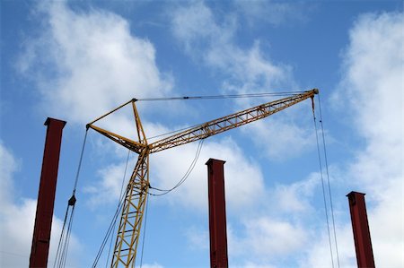 yellow crane and purple constructions under blue cloudy sky Stock Photo - Budget Royalty-Free & Subscription, Code: 400-05042997