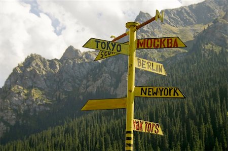 The signpost from meta indicating a managements seven large cities of the world, on a background of mountains. Stockbilder - Microstock & Abonnement, Bildnummer: 400-05054305